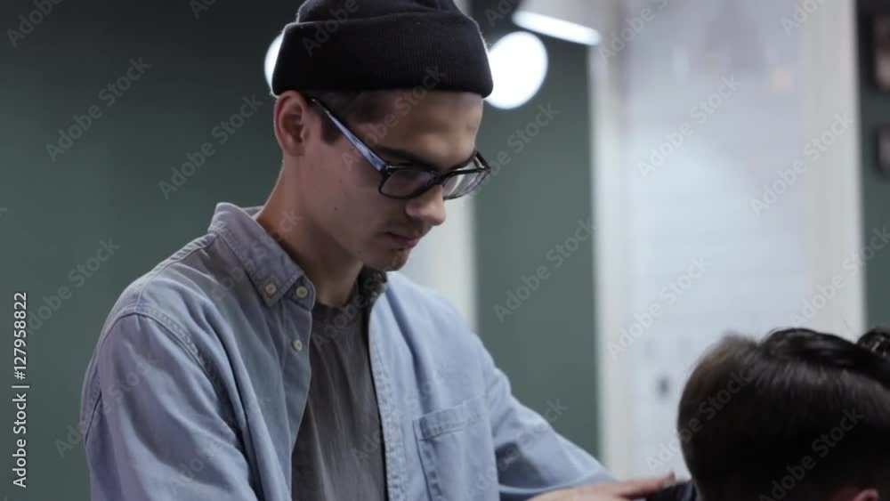 Handsome man with beard in barbershop. Barber working with electric razor. Handsome man with beard in barbershop. Barber working with electric razor.