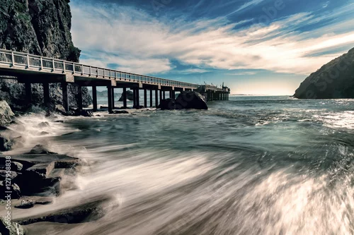 Obraz widok na ocean, skały i most