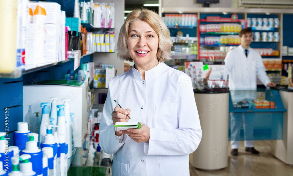 Portrait of two smiling pharmacists working in  farmacy