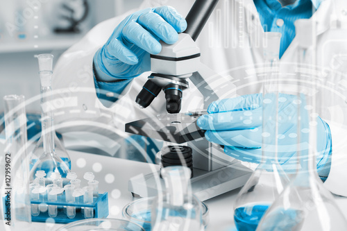 men in a laboratory microscope with microscope slide in hand