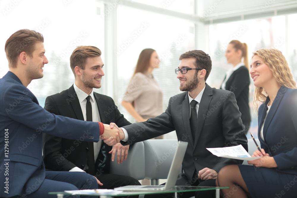 Handshake between businesspeople in a modern office Handshake between businesspeople in a modern office