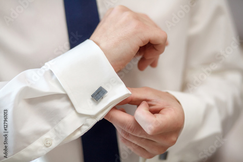 Elegant fashion man fixing his cufflinks, closeup