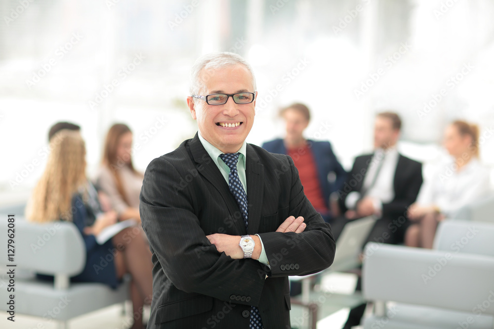 Portrait of happy businessman with  colleagues interacting on ba