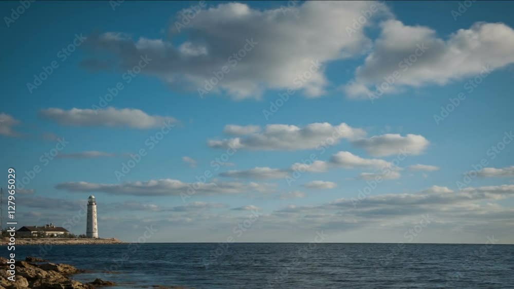 Lighthouse on the seashore under clouds. Timelapse Lighthouse on the seashore under clouds. Timelapse