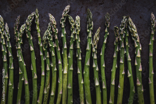 fresh asparagus spears on a dark metal surface