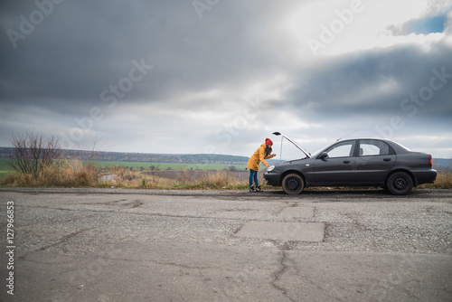 Young woman with broken car