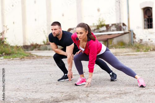 Young fitness couple stretching their muscles before running.