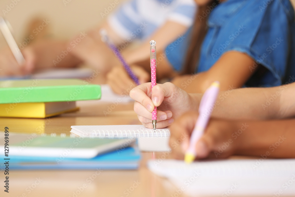 Children hands writing in copybooks, closeup Children hands writing in copybooks, closeup