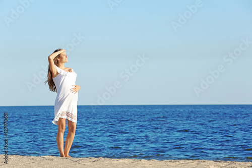 Young pregnant woman in whi...