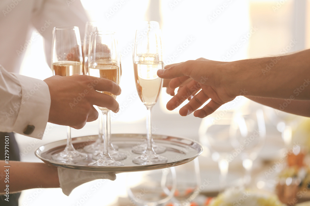 Hands taking glasses with champagne from metal tray, close up view