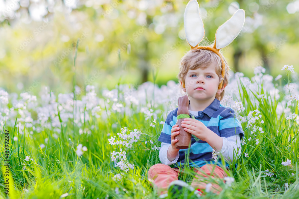 Little kid with Easter bunny ears and chocolate Little kid with Easter bunny ears and chocolate
