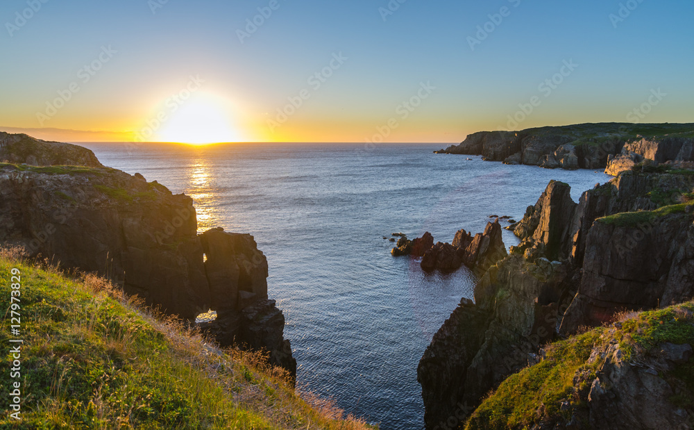 Daybreak over Atlantic ocean. Dramatic sunrise August morning summer sun breaks over the Atlantic in Lancaster and Cable John Cove, Newfoundland, Canada. Daybreak over Atlantic ocean. Dramatic sunrise August morning summer sun breaks over the Atlantic in Lancaster and Cable John Cove, Newfoundland, Canada.