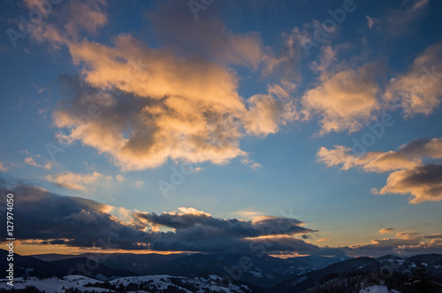 Winter sunset in the mountains. Multi-colored clouds, illuminated by the sun. © vladk213
