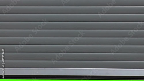 shot of an opening metal garage door with greenscreen in the background