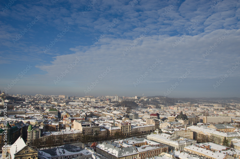 Fototapeta premium Winter panorama of Lviv covered by snow, Ukraine.Lviv or Lvov, Eastern Ukraine - the view of the city from the city hall clock tower.
