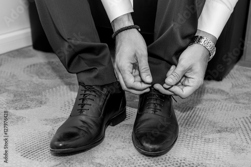 Groom tying shoelaces.