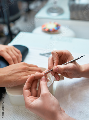 procedure cuticle cutting the nails, client's hand and manicure