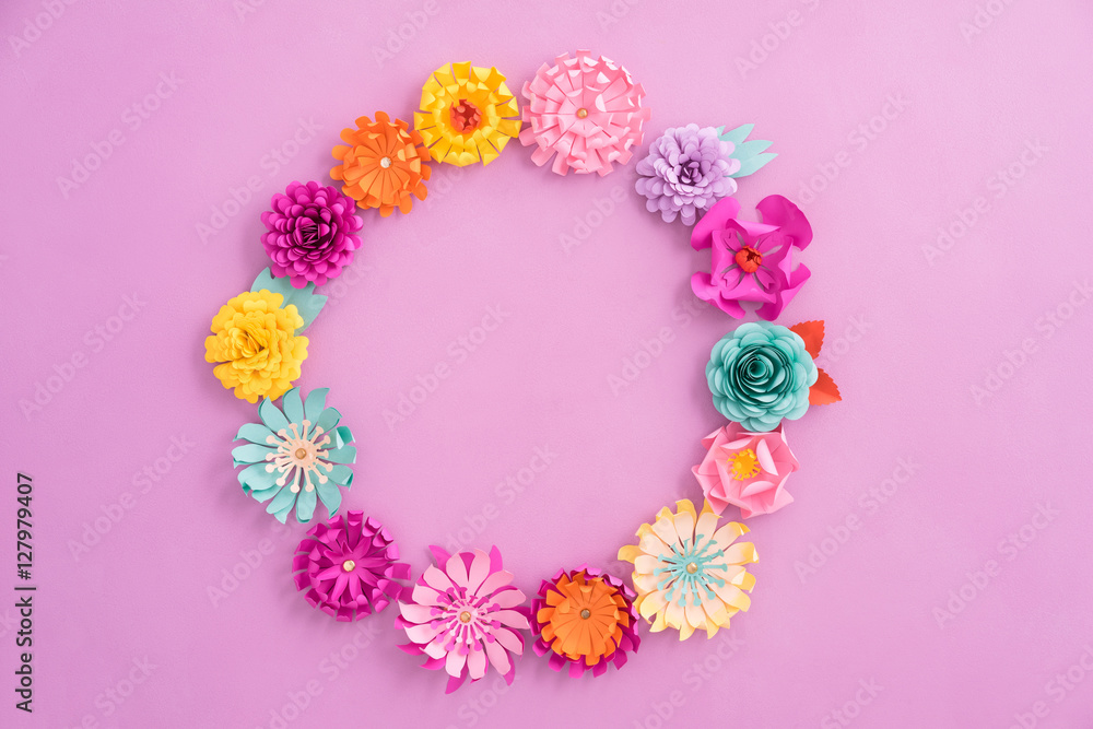 Colourful wreath made of handmade paper flowers on pink background