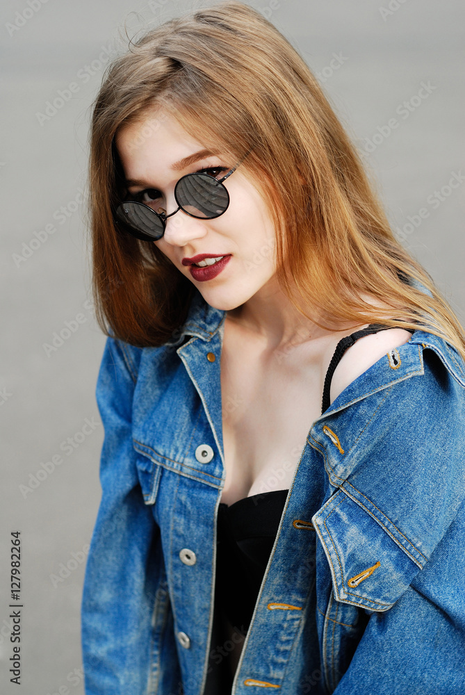 model in a black top and a denim jacket looking at the camera model in a black top and a denim jacket looking at the camera