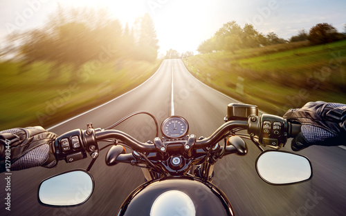 POV shot of young man riding on a motorcycle. Hands of motorcycl photo