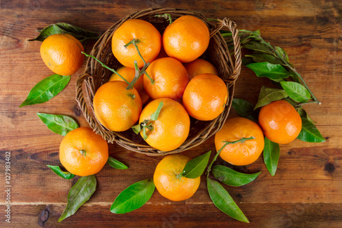 Tangerines basket over old wooden table top view