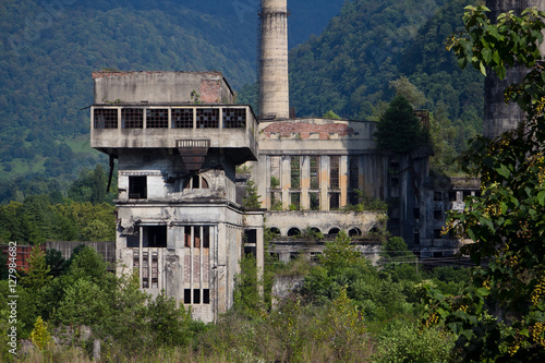 Foto Abandoned, destroyed by war and overgrown machinery of Tkvarcheli power plant, A