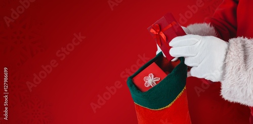 Composite image of santa claus with christmas present