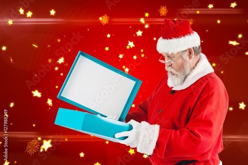 Composite image of santa claus opening gift box