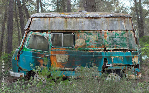 Hippie old van abandoned in forest
