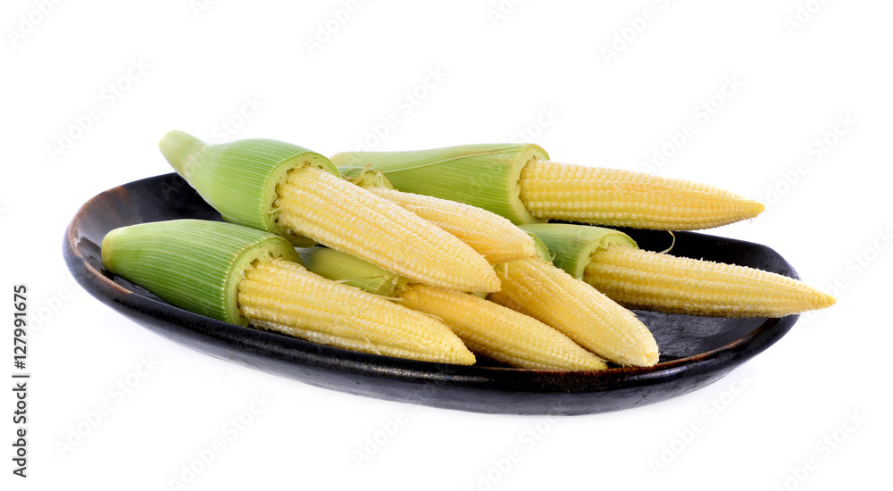 young small corn in black plate on white background young small corn in black plate on white background