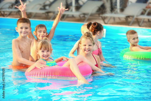 Little kids in swimming pool on sunny day