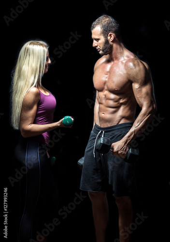 Slim fitness couple with dumbbells