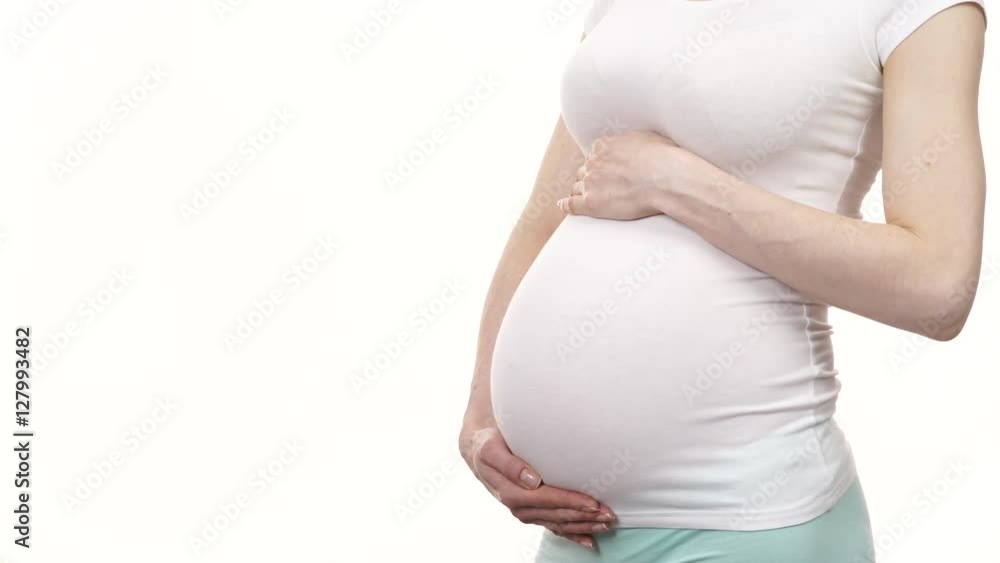 Pregnant woman wearing bright tshirt standing showing her big belly