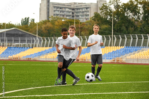 Boys playing football at stadium © Africa Studio