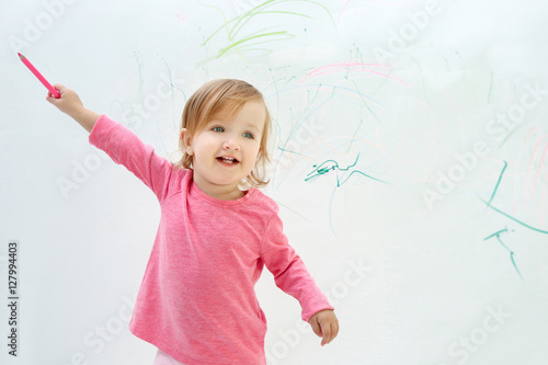 Cute little girl drawing on...