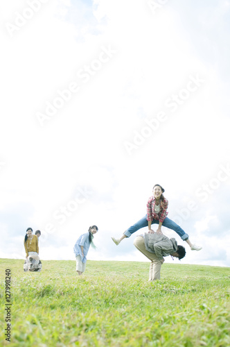 草原で馬跳びをする若者たち