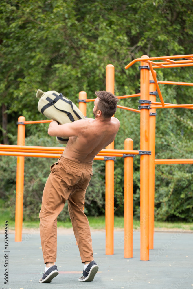 Obraz premium Man Performing Bag Squat Exercise Outdoor