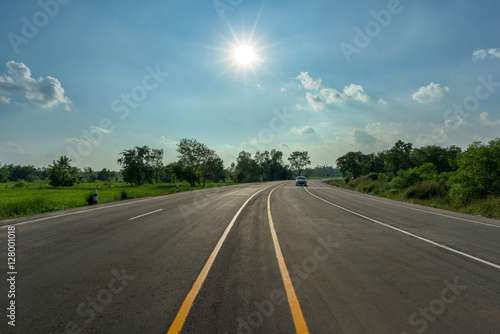 asphalt road and sun on blue sky © yotrakbutda