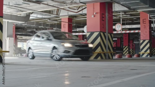 Woman in car driving through parking lot, then stopping before camera