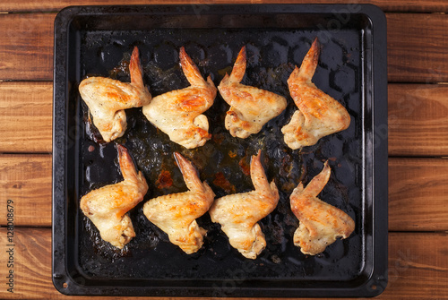 Tasty grilled chicken wings on baking sheet