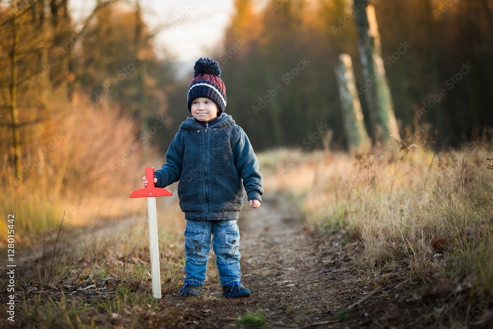 Young boy playing outdoor with wooden sword Young boy playing outdoor with wooden sword