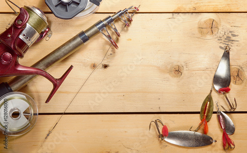 Fishing composition with angling equipment on wooden background