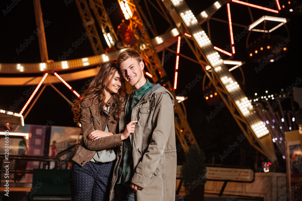 Portrait of joyful young couple in amusement park