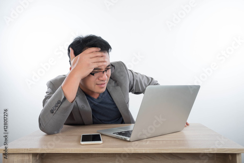 young businessman Stressful jobs using a laptop sitting thinking