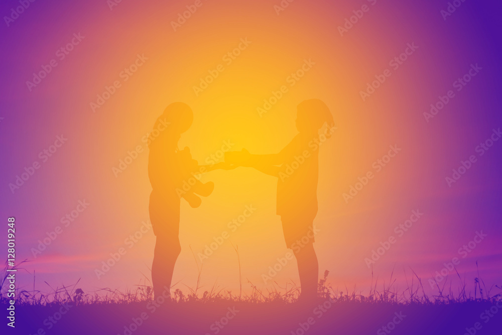 Silhouette of children holding gift box at the sky sunset, happy time in holiday, Christmas and happy new year concept Silhouette of children holding gift box at the sky sunset, happy time in holiday, Christmas and happy new year concept