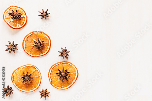 Christmas food - mulled wine background. Decorative frame of spice ingredients - anise stars, cinnamon, dried oranges and wine on wood white surface. Top view.