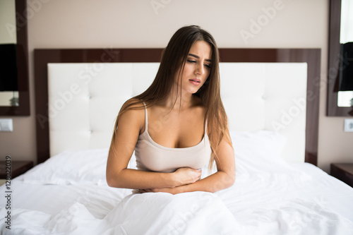 Young woman sitting on the bed with pain © F8  \ Suport Ukraine