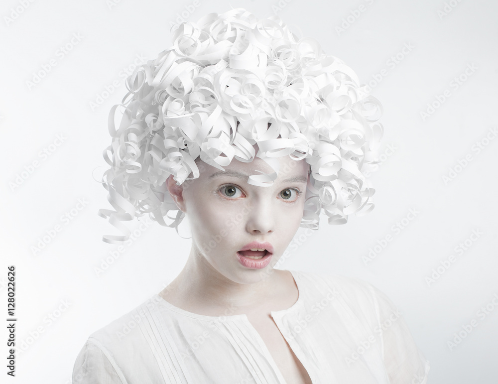 Portrait of a surprised girl with curly hair paper..