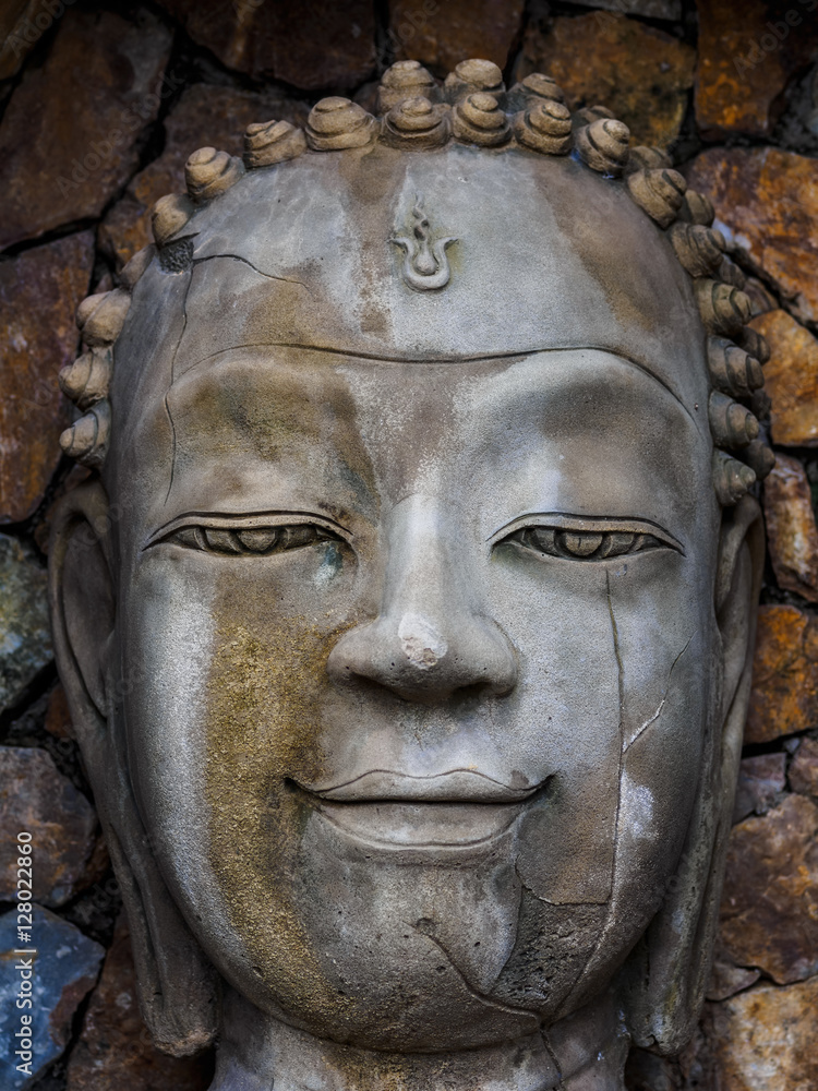 Sandstone face of Buddha in the niche of the wall Sandstone face of Buddha in the niche of the wall