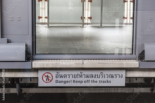 Danger sign with closing door in the train station photo